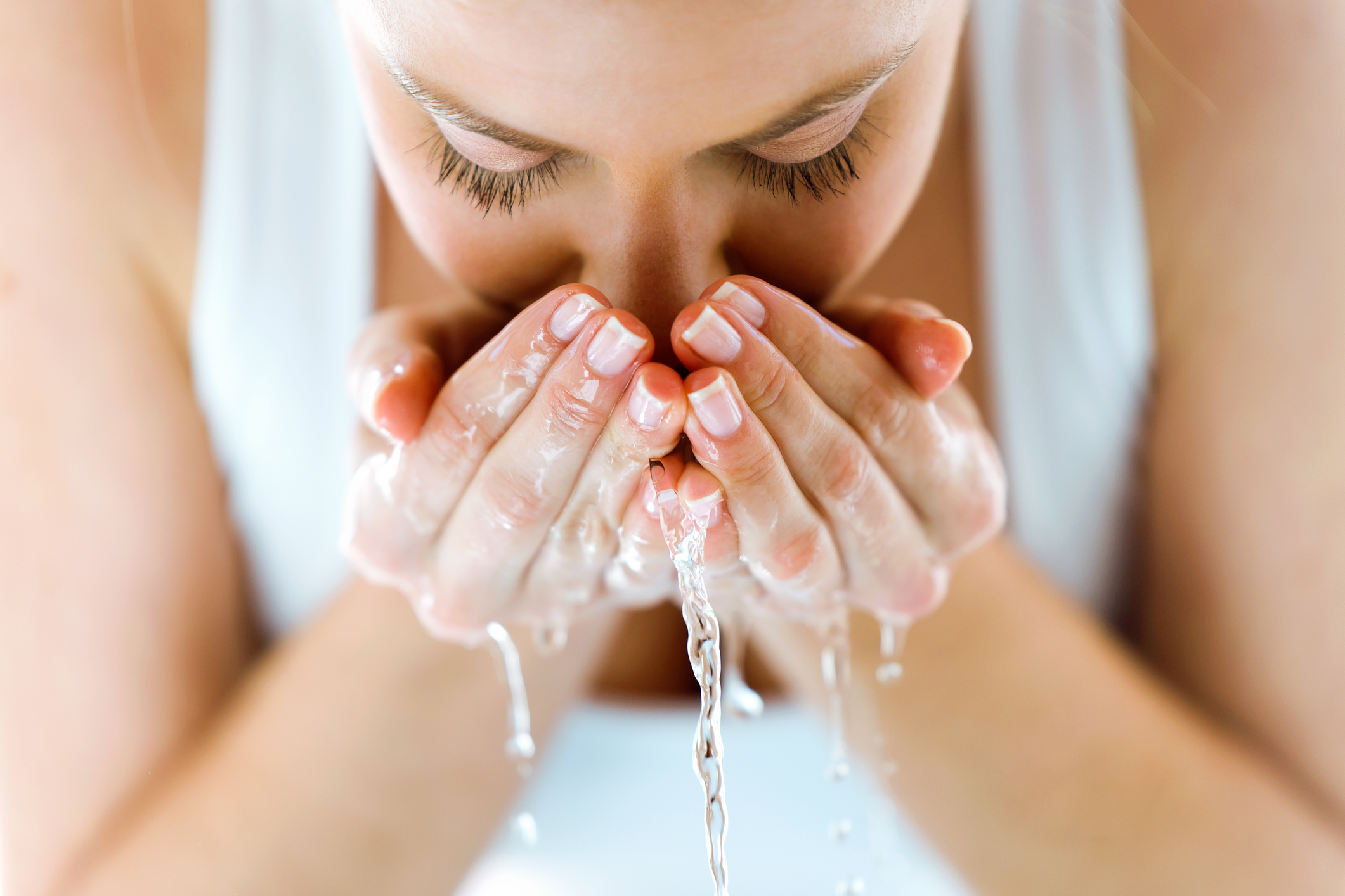 Beautiful Young Woman Washing Her Face Splashing Water In A Home